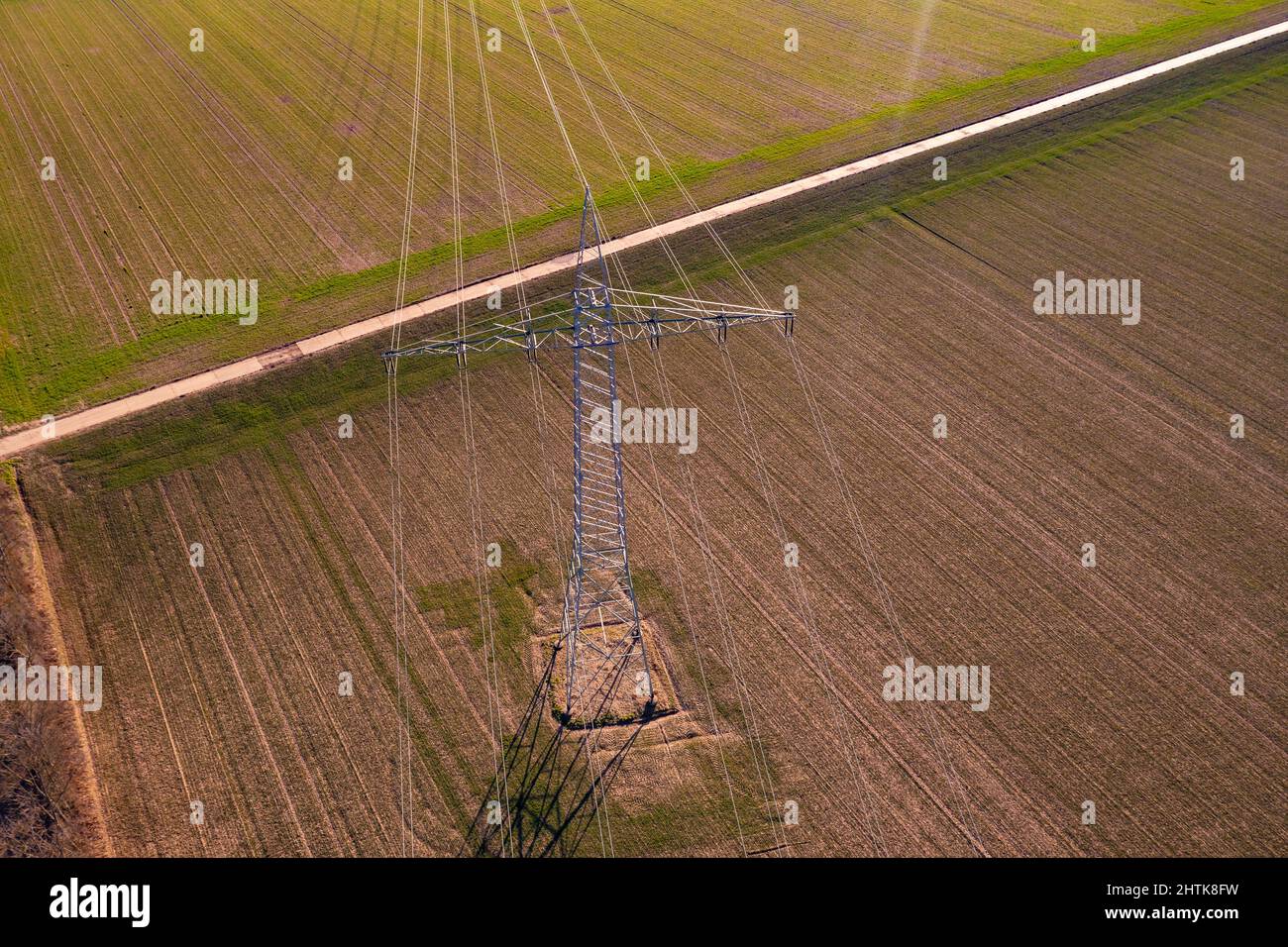 Vista aerea delle linee elettriche su un polo di potenza in un campo in inverno Foto Stock