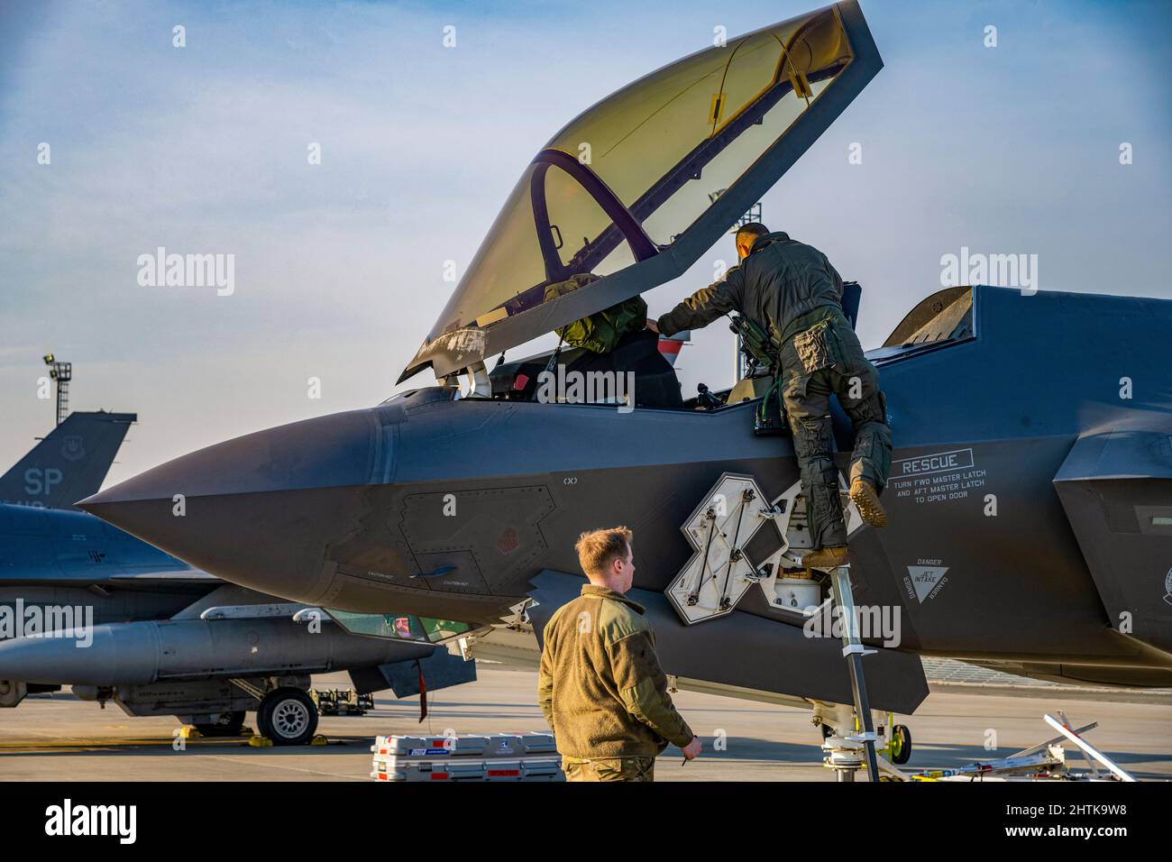 Borcea, Romania. 26 Febbraio, 2022. Un pilota dell'aeronautica statunitense F-35 Lightning II con l'ala 388th Fighter, si arrampica nel suo velivolo mentre si prepara per una missione di pattuglia aerea alla base aerea RoAF 86th, 26 febbraio 2022 a Balcea, Romania. Gli aerei di guerra sono schierati per le operazioni di polizia aerea rafforzata della NATO per contrastare il trattamento della Russia contro l'Ucraina. Credit: SRA Ali Stewart/US Air Force/Alamy Live News Foto Stock