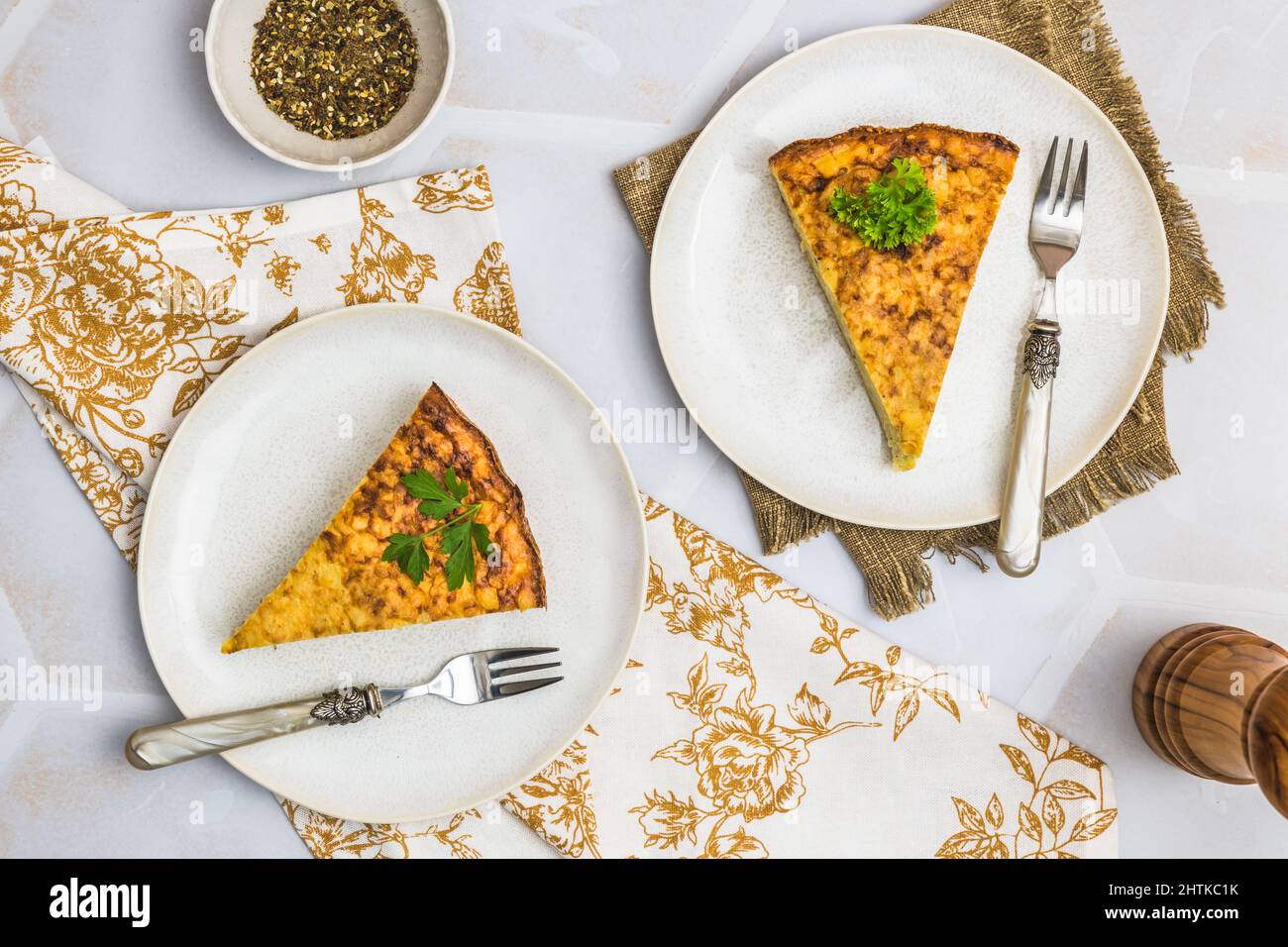 Due pezzi di una torta di patate, tortilla spagnola, frittata, su sfondo bianco, vista dall'alto Foto Stock