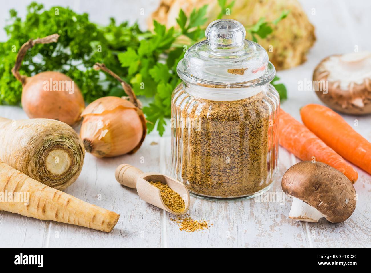 Brodo vegetale in polvere fatto in casa, brodo vegetale organico, con verdure crude su sfondo bianco di legno Foto Stock