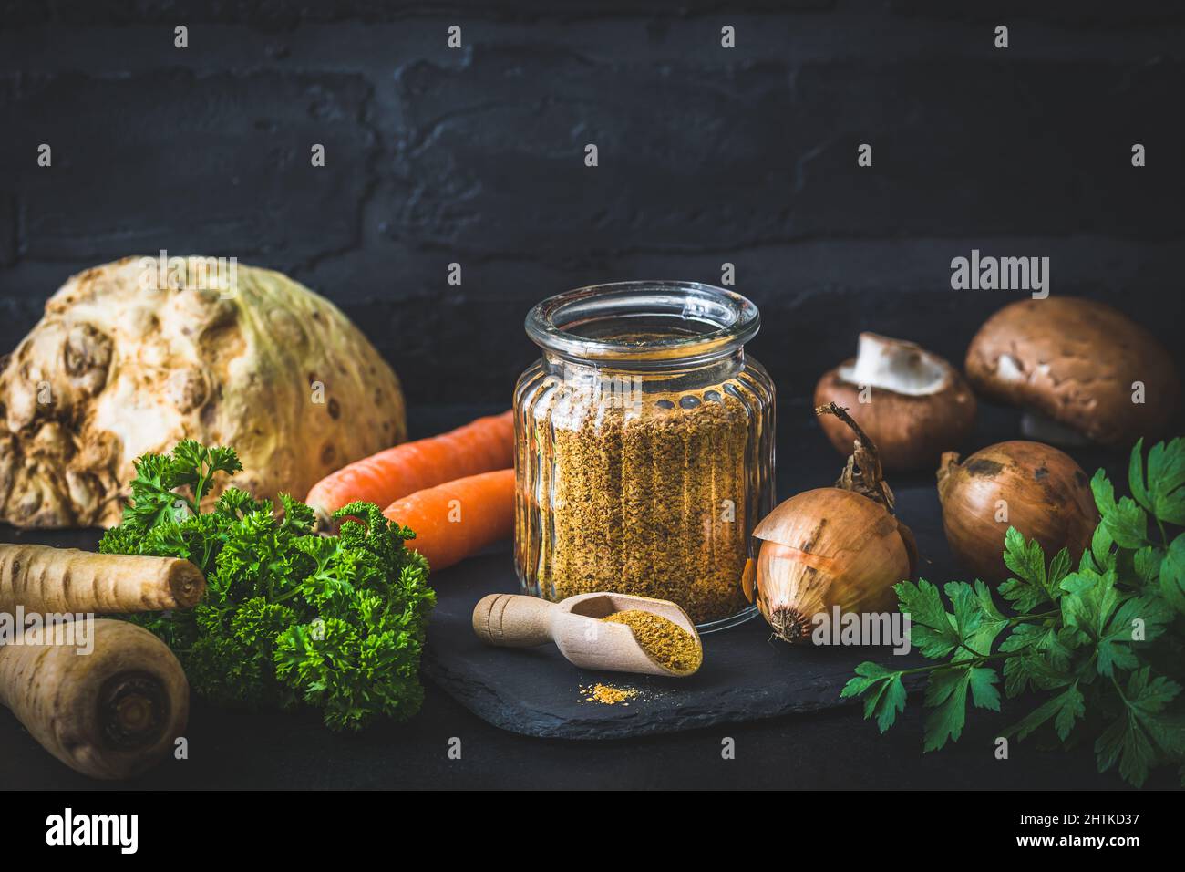 Brodo vegetale in polvere fatto in casa, brodo vegetale organico, con verdure crude su sfondo nero, spazio copia Foto Stock