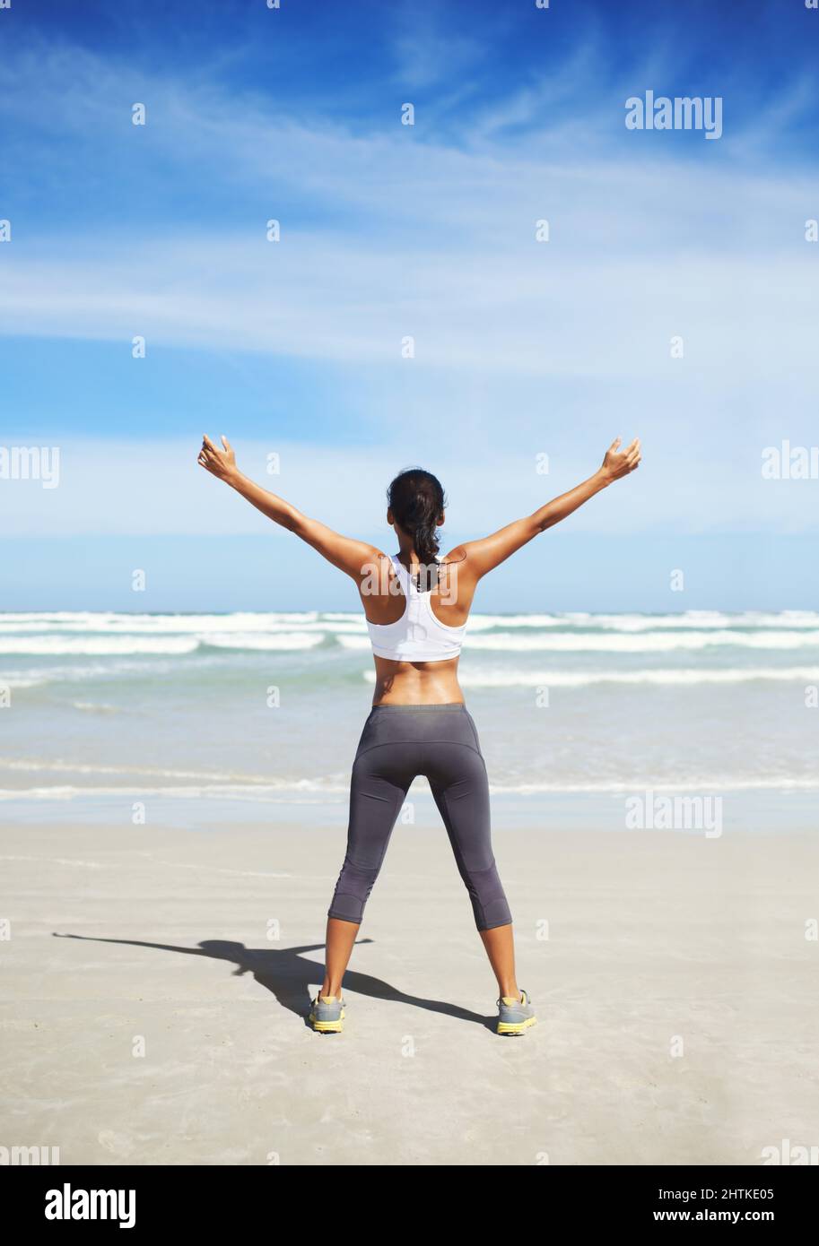 Forma e salute. Un giovane pareggiatore in piedi sulla spiaggia. Foto Stock