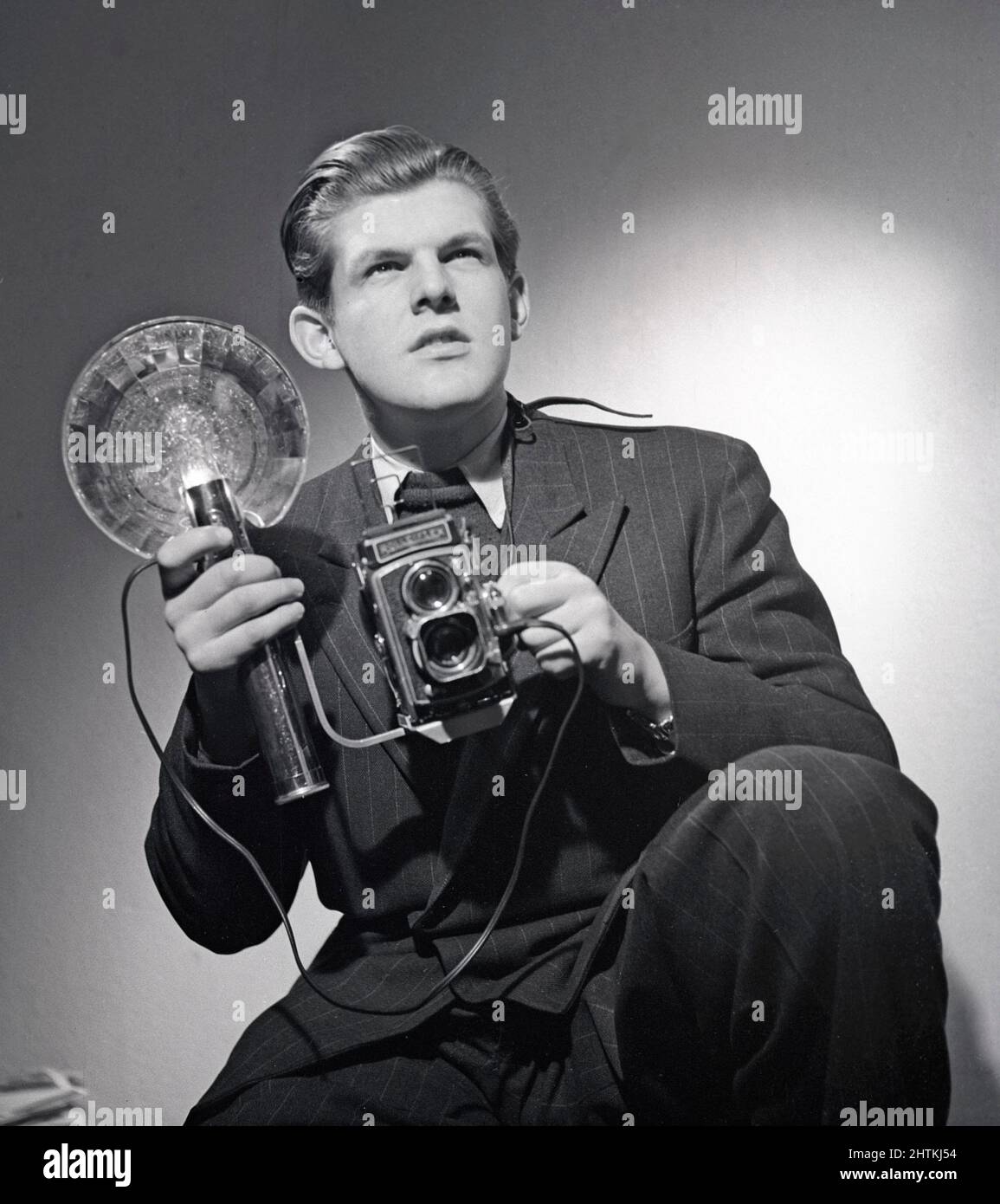 Presentatore del 1940s. Anders Swahn ha raffigurato una fotocamera Rolleiflex e un'unità flash portatile. Un'attrezzatura standard per i fotografi di stampa in questo momento. Svezia 1949 Kristoffersson Ref AA40-4 Foto Stock
