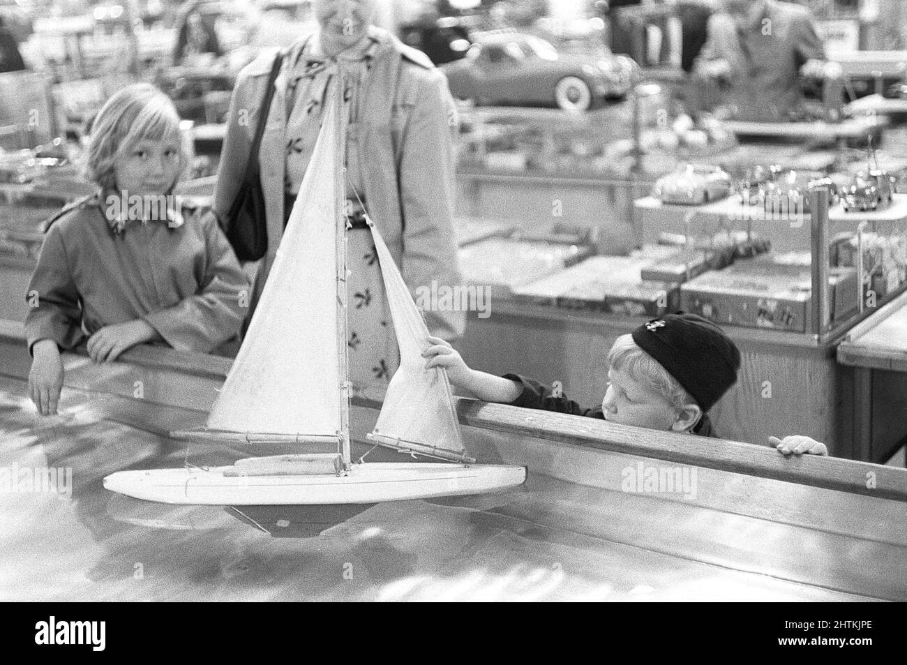 Giocattoli nel 1950s. In un grande magazzino un ragazzo è curioso della bella barca a vela modello galleggiare in acqua e toccarla. Svezia 1954 Kristoffersson Ref 2A-33 Foto Stock