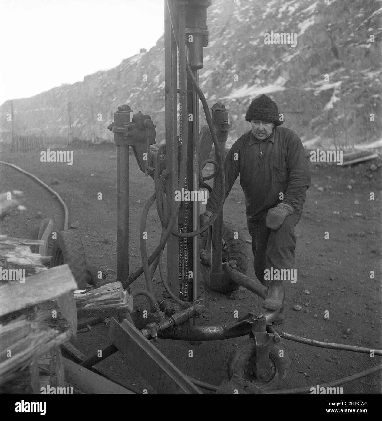 Kiruna Svezia nel 1950s. La miniera aperta e i lavoratori che perforano fori per mettere esplosivi in. Il trapano è alimentato da aria compressa e il rumore sarebbe stato molto alto, ma l'uomo che lavora con esso sembra non notare il suono anche senza indossare alcuna protezione per le orecchie. Potrebbe già avere un'audizione così brutta che il problema del rumore alto non è un problema. Svezia 1954 Kristoffersson BP22-9 Foto Stock