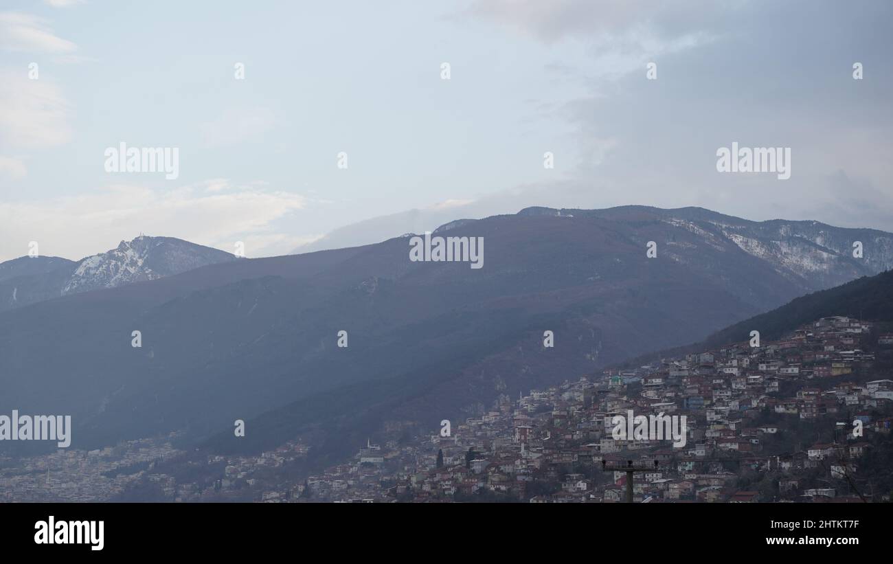 Vista sulle montagne e sulla città in tempo nuvoloso Foto Stock