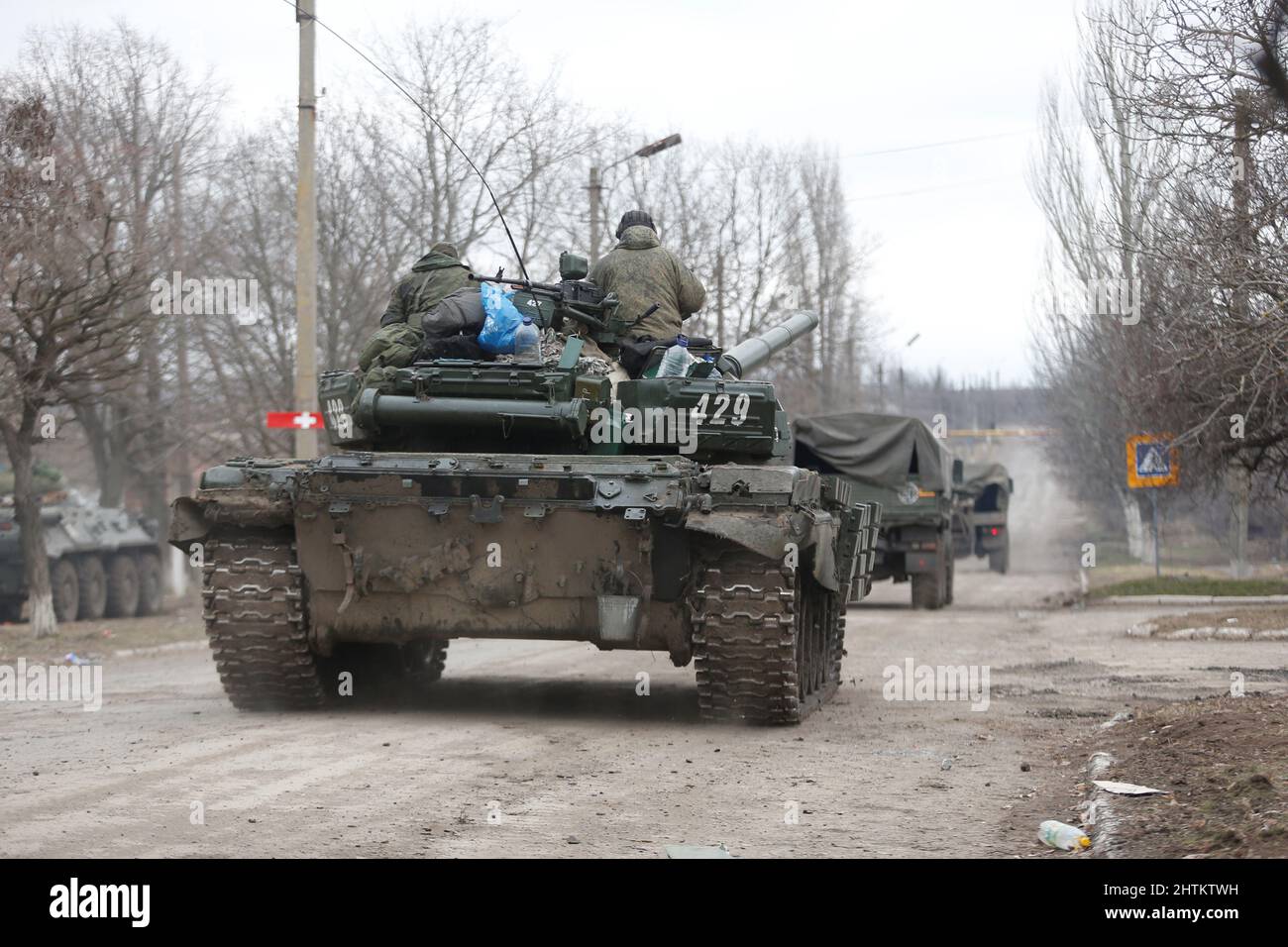 I membri di servizio delle truppe pro-russe in uniformi senza insegne sono visti in cima ad un carro armato nell'insediamento controllato dai separatisti di Mykolaivka (Nikolaevka), mentre l'invasione russa dell'Ucraina continua, nella regione di Donetsk, Ucraina, 1 marzo 2022. REUTERS/Alexander Ermochenko Foto Stock
