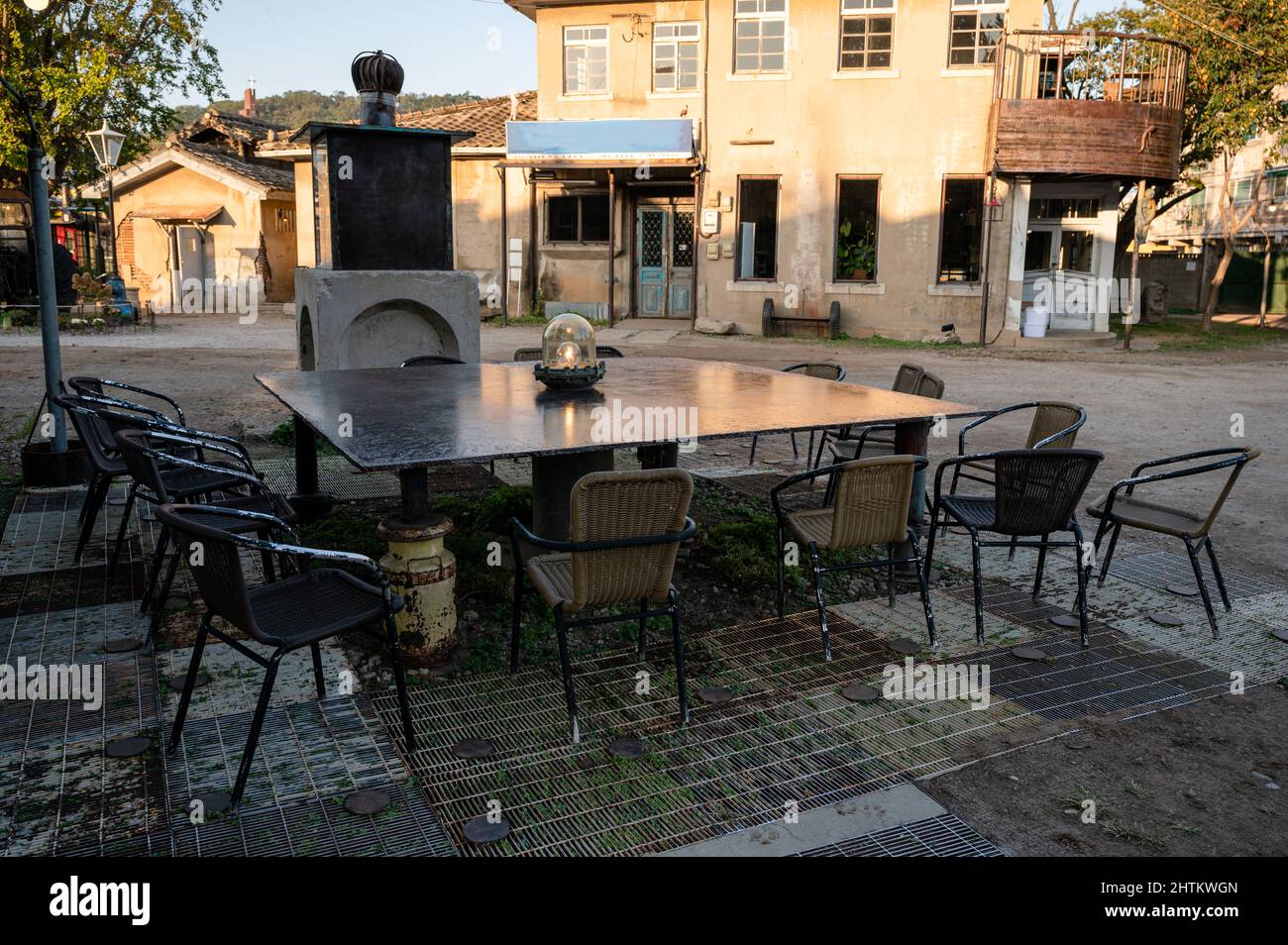Tavolo in metallo ruggine con sedia a tessitura e lampada. Caffè in stile loft Foto Stock