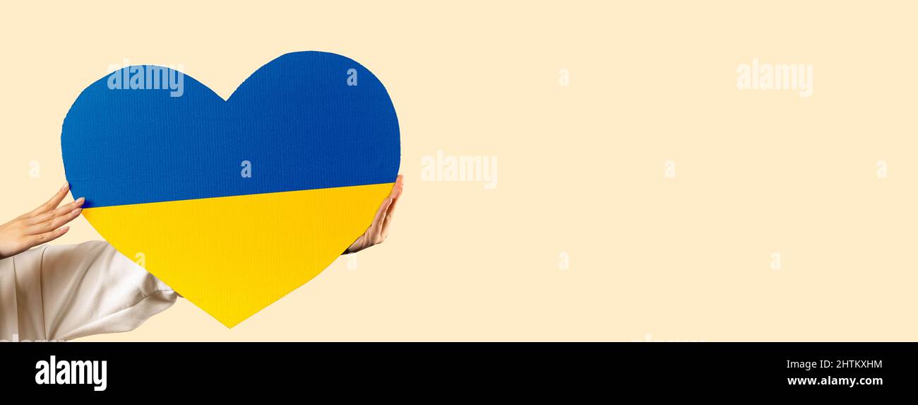 Banner. Cartone cuore i colori della bandiera Ucraina, isolato sullo sfondo. Un appello alla pace e alla fine della guerra. Nessuna guerra, basta la guerra. Foto Stock