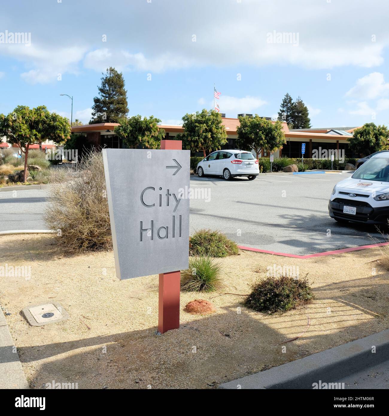 Cartello con la freccia che indica il municipio; Millbrae, California, l'edificio amministrativo principale degli Stati Uniti e sede del consiglio governativo locale eletto. Foto Stock
