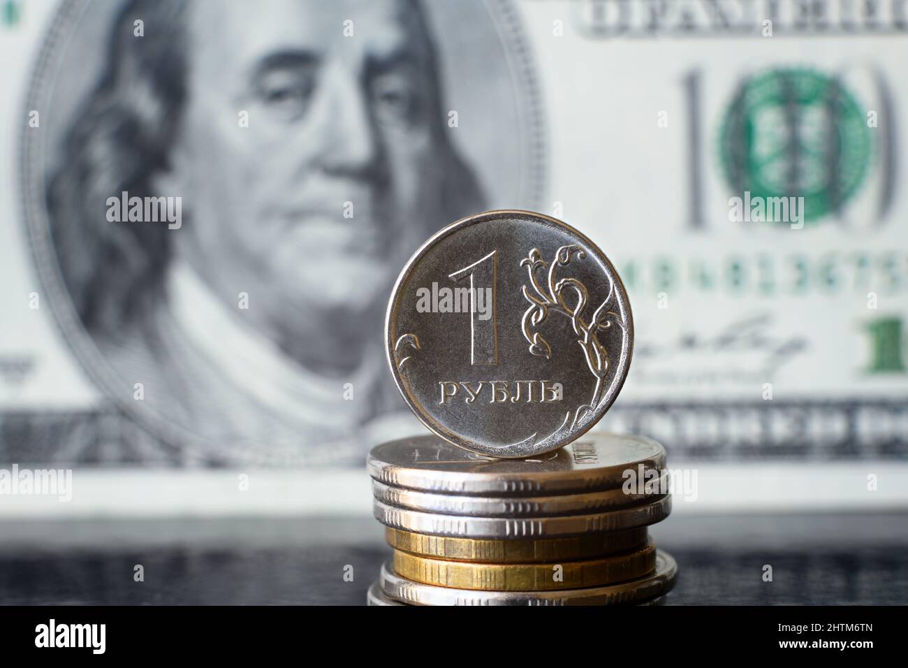 Moneta rublo russa sullo sfondo della bolletta del dollaro, il denaro rublo è sotto pressione dalla geopolitica. Concetto di svalutazione rubabile, inflazione in Russia, ce Foto Stock