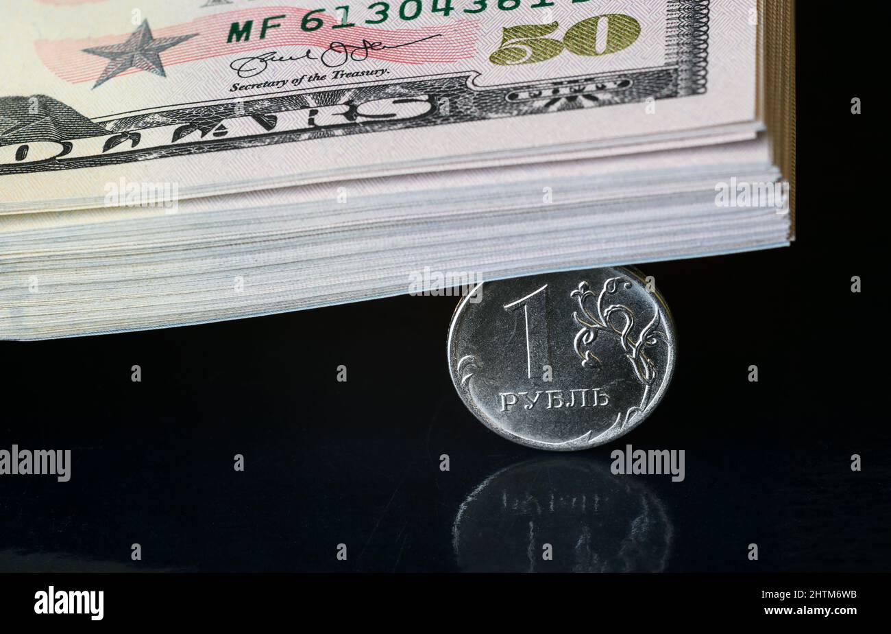 Moneta rublo russa schiacciata da una pila di dollari, il denaro rublo è sotto pressione dalla geopolitica. Concetto di svalutazione rubabile, inflazione in Russia Foto Stock