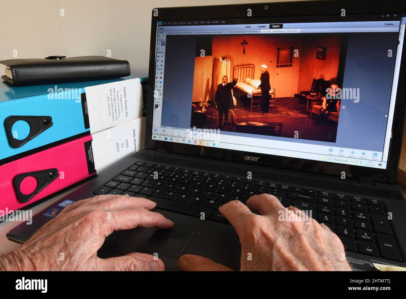 Vecchie mani alla tastiera di un computer trovare le immagini per attivare ricordi piacevoli come uno diventa più vecchio. Questa produzione della commedia Loot nel Lowenthal Foto Stock