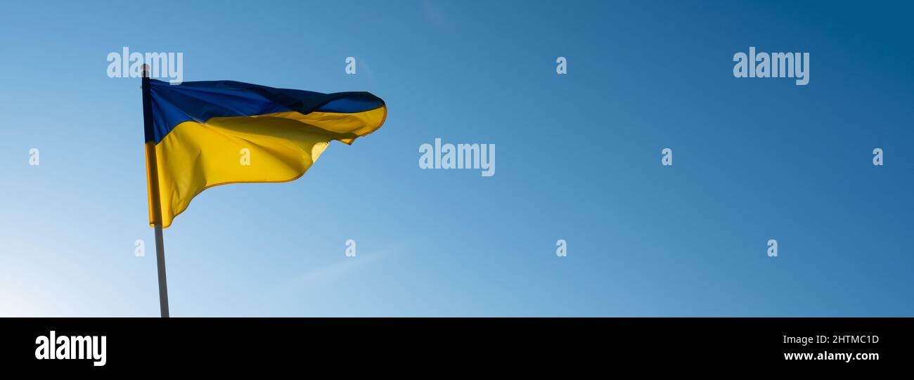 Banner bandiera ucraino con spazio di copia vuoto. Bandiera dell'Ucraina su sfondo cielo blu. Simbolo nazionale di libertà e indipendenza. "Ucraini lavici!" Foto Stock