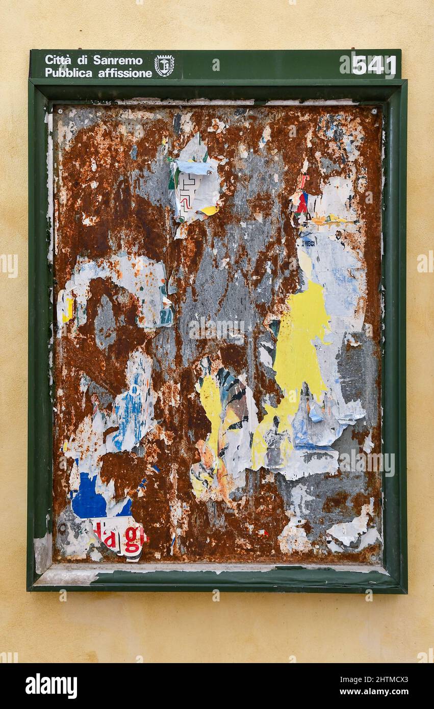 Primo piano di una cornice per l'invio pubblico con pezzi di poster strappati su un muro giallo nel centro storico di Sanremo, Imperia, Liguria, Italia Foto Stock Primo piano di una cornice per l'invio pubblico con pezzi di poster strappati su un muro giallo nel centro storico di Sanremo, Imperia, Liguria, Italia Foto Stock