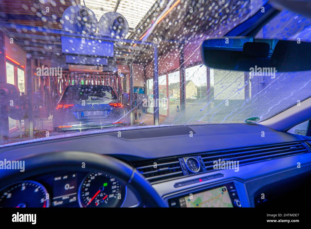 Auto in autolavaggio automatico, linea autolavaggio, schiuma detergente spruzzata, spazzole rotanti pulire il veicolo, Foto Stock
