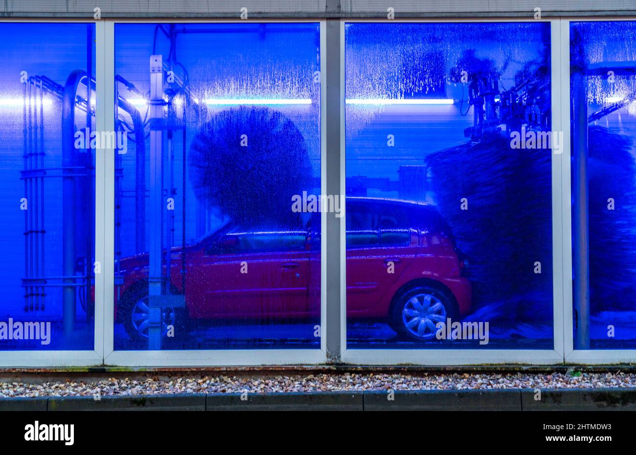 Auto in autolavaggio automatico, linea autolavaggio, schiuma detergente spruzzata, spazzole rotanti pulire il veicolo, Foto Stock