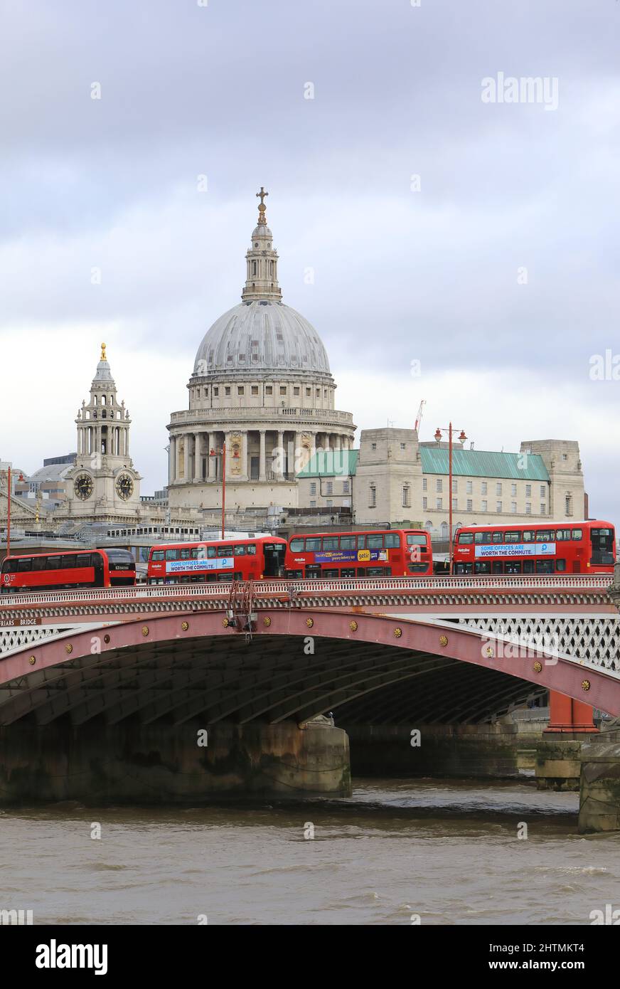 Linea di autobus rossi che attraversa il Blackfriars Bridge con la Cattedrale di St Pauls oltre, a Londra, Regno Unito Foto Stock