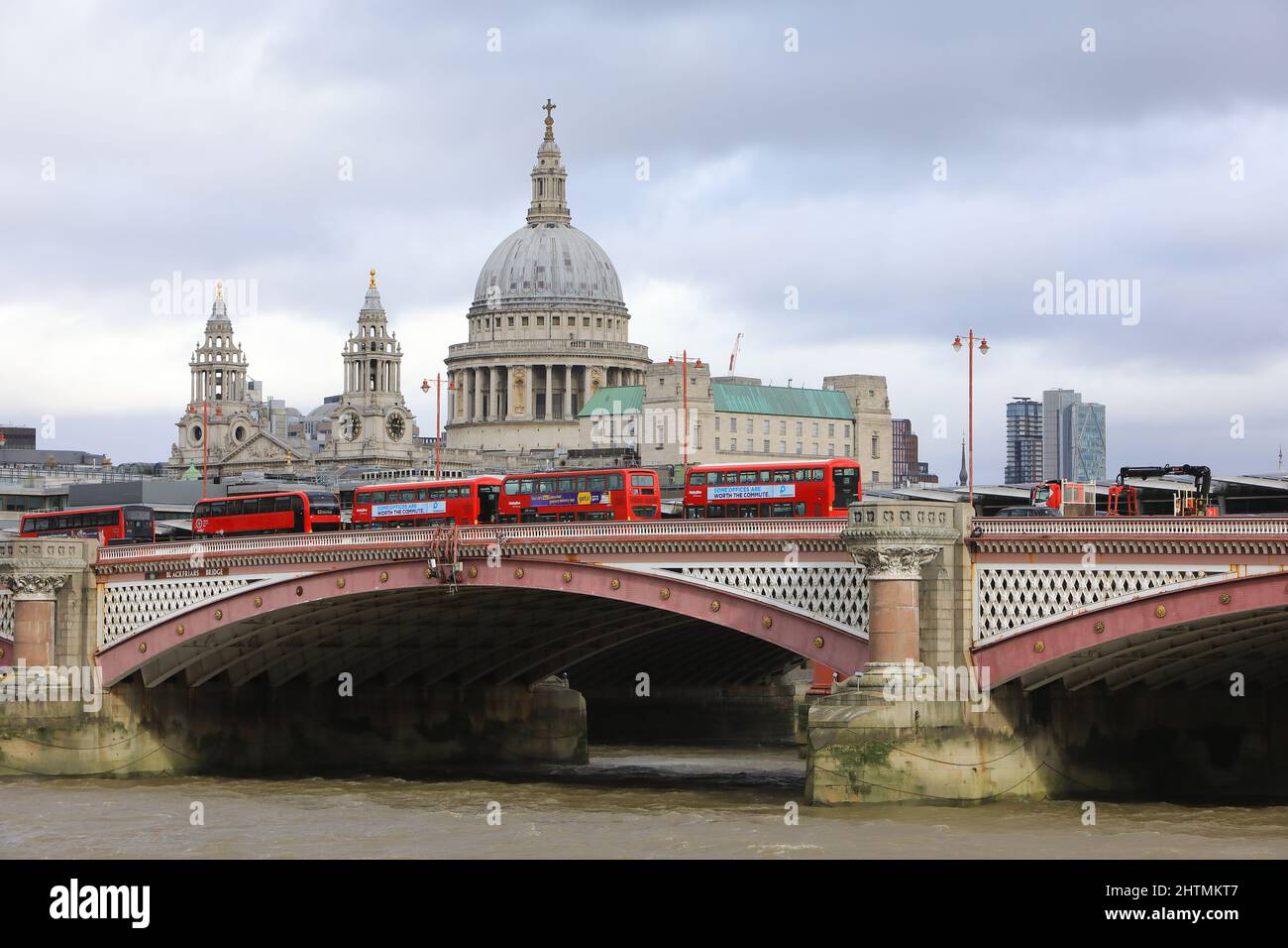 Linea di autobus rossi che attraversa il Blackfriars Bridge con la Cattedrale di St Pauls oltre, a Londra, Regno Unito Foto Stock