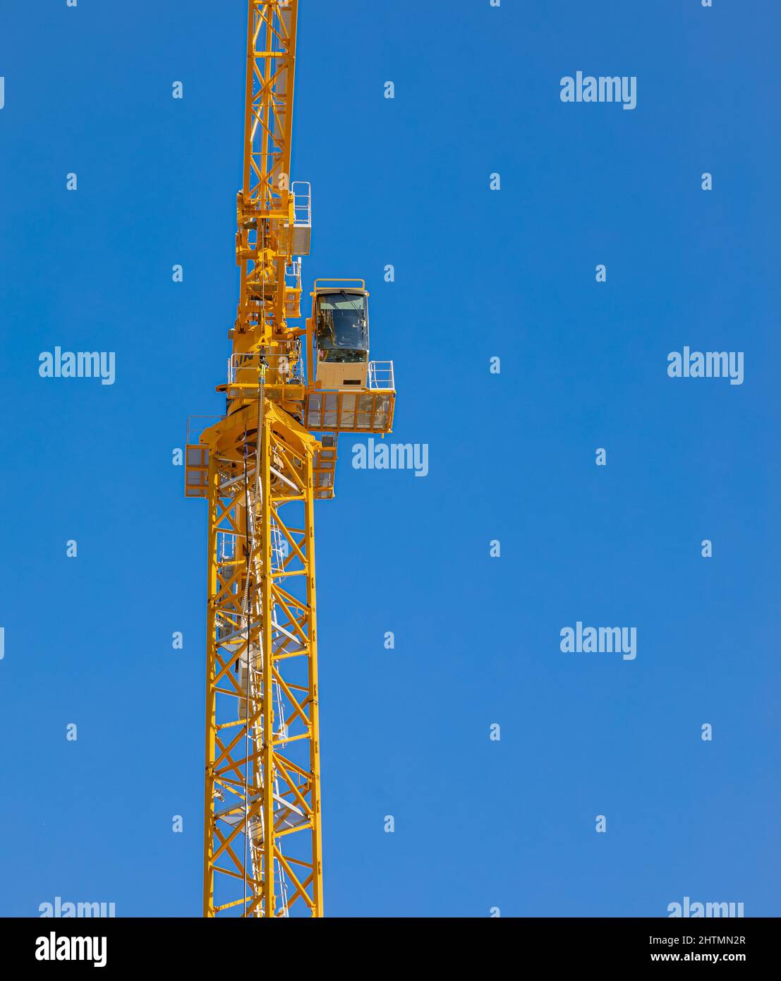 Alta gru da sola contro il cielo blu. Grande gru alta sotto un nuovo cantiere. Nessuno, fuoco selettivo, spazio di copia per il testo Foto Stock