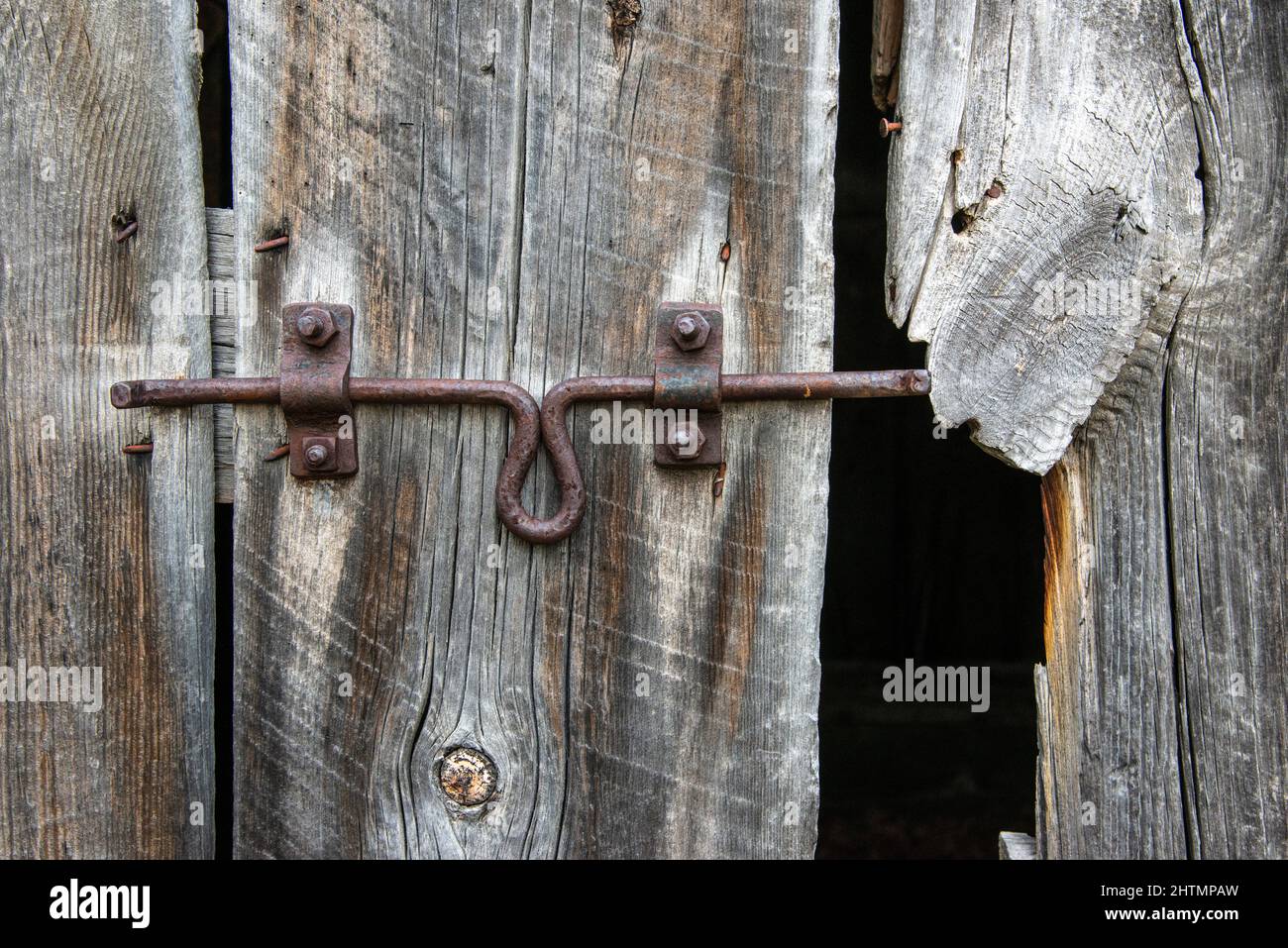 serratura scorrevole sulla vecchia porta del fienile Foto Stock