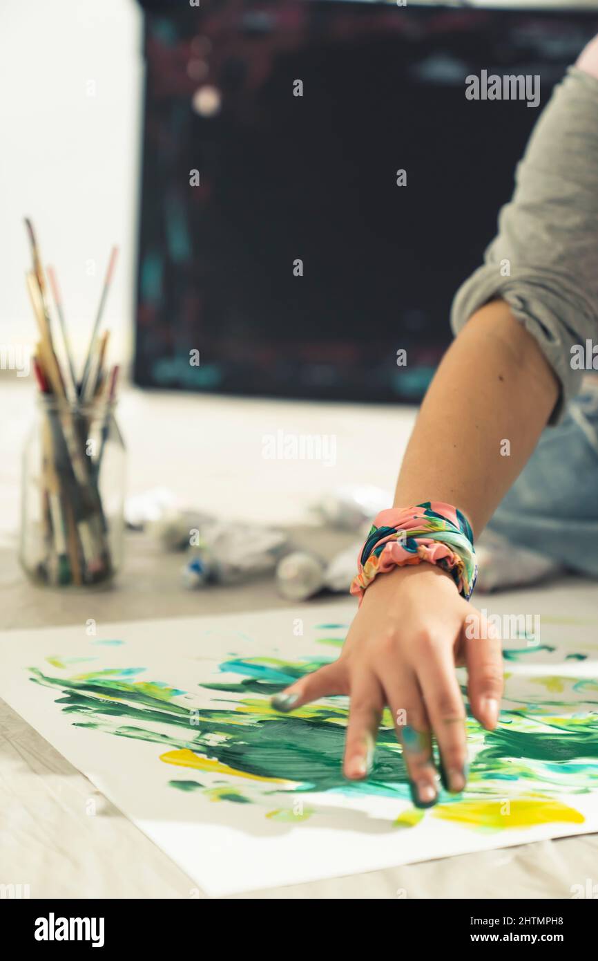 Arte astratta l'artista moderno dipinge con le mani sul foglio di carta. Primo piano. Foto di alta qualità Foto Stock