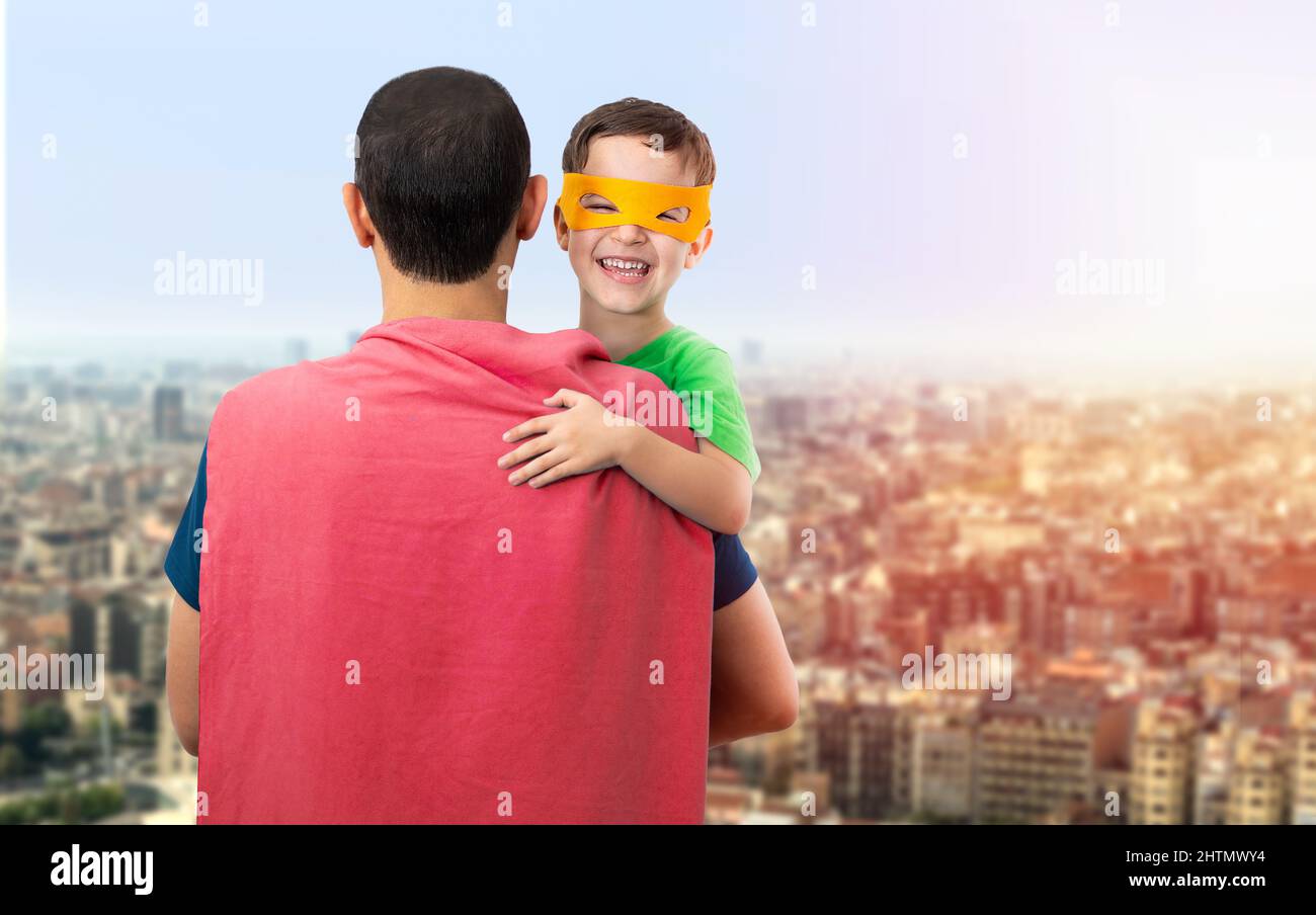 Felice padre amorevole. Papà e suo figlio che giocano all'aperto. Papà e ragazzo vestito come Supereroi. Concetto del giorno del Padre. Foto Stock