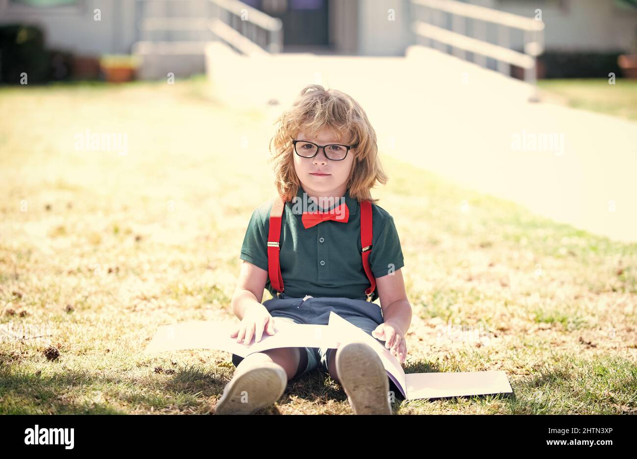 intelligente curioso nerd in occhiali lettura libro studio con copybook all'aperto, genio Foto Stock