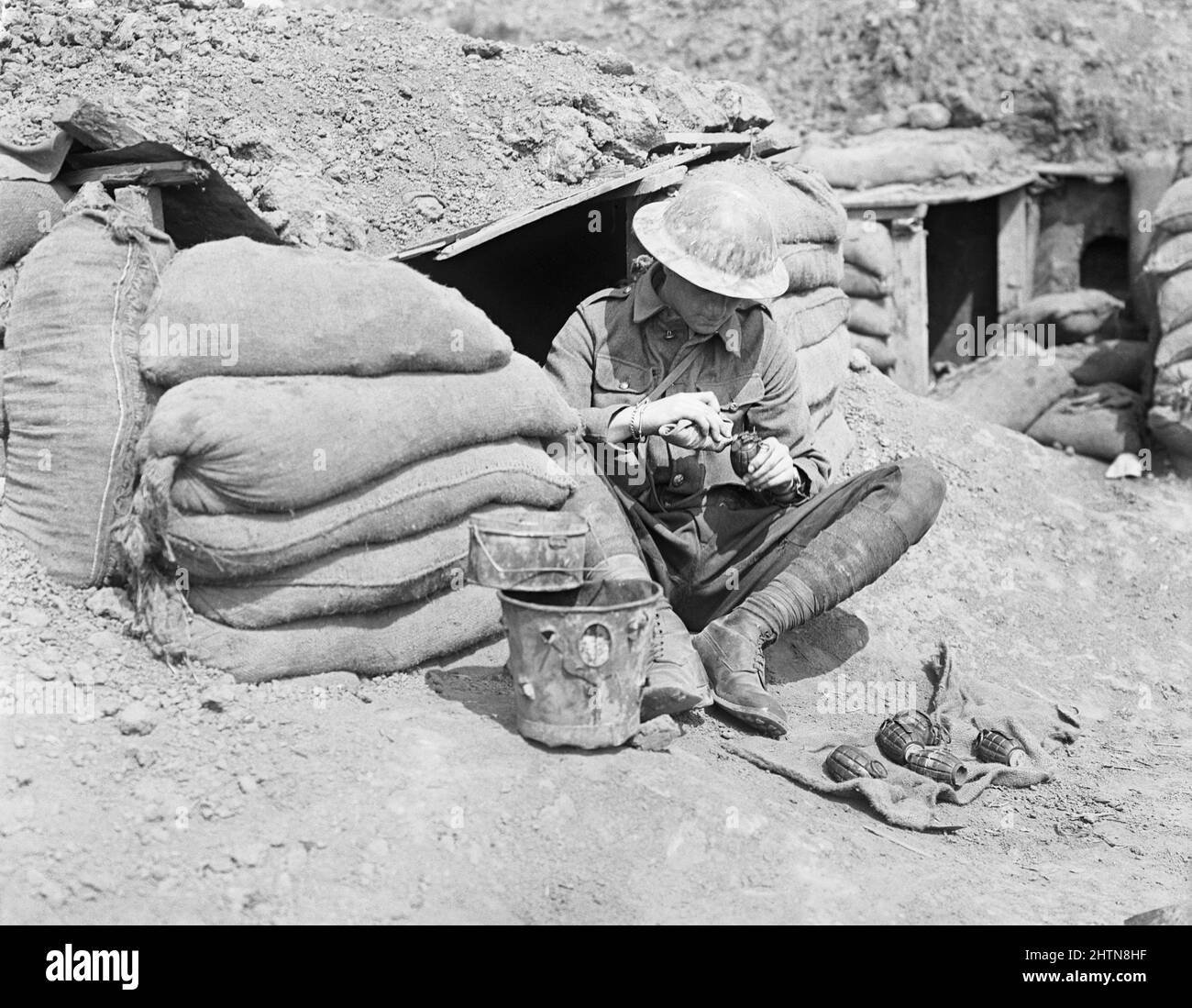 Il soldato britannico controlla le bombe Mills all'ingresso del suo dugout. Foto Stock