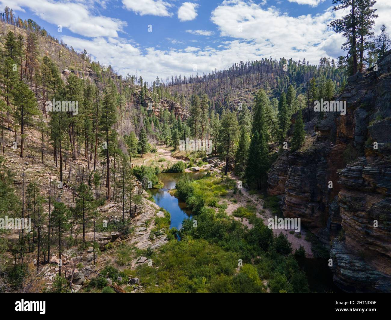 Ruscello che scorre attraverso un canyon con montagne tutto intorno. Foto Stock