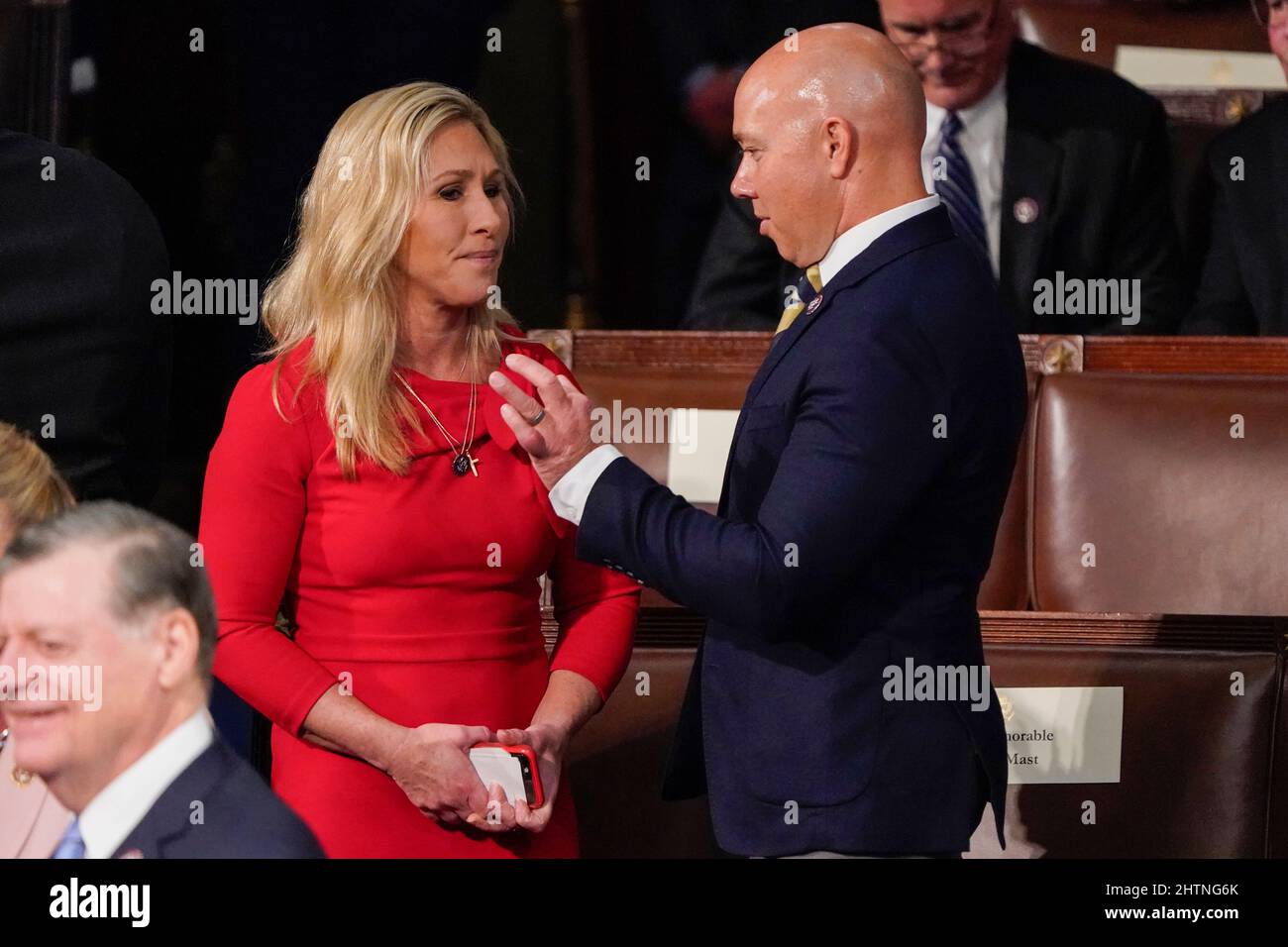 Il Rappresentante degli Stati Uniti Marjorie Taylor Greene (repubblicano della Georgia), parla con il Rappresentante degli Stati Uniti Brian Mast (repubblicano della Florida) prima che il Presidente Joe Biden esprima il suo primo discorso dello Stato dell'Unione ad una sessione congiunta del Congresso, in Campidoglio a Washington, martedì 1 marzo 2022. Credit: J. Scott Applewhite/Pool via CNP Foto Stock