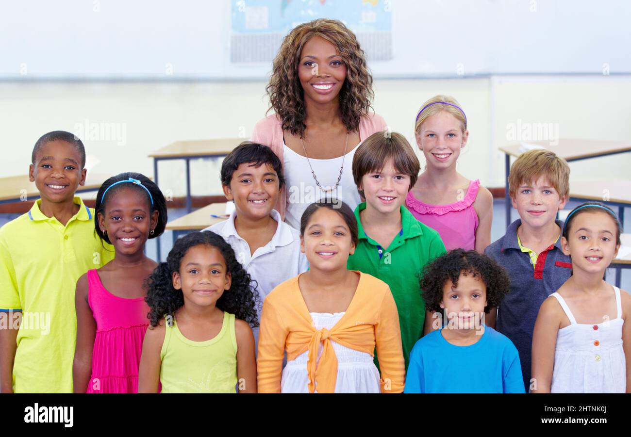 Immagine della classe. Ritratto di classe di un insegnante di scuola elementare e delle sue alunne. Foto Stock