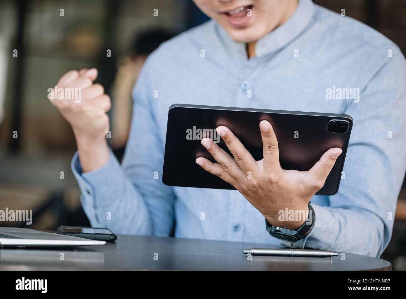 concetto di analisi dei profitti del mercato azionario, gestione dei rischi, libertà finanziaria, marketing di borsa maschile utilizzando tablet, esprimendo gioia nell'acquisto e nella vendita Foto Stock