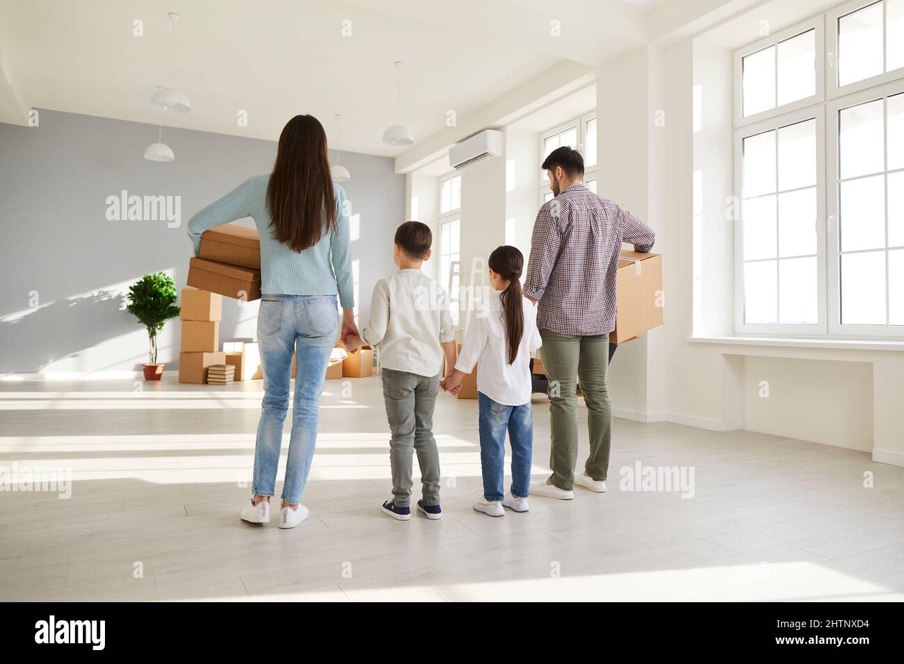 Famiglia con figli che acquistano casa o appartamento nuovo e si trasferiscono nella loro casa da sogno Foto Stock