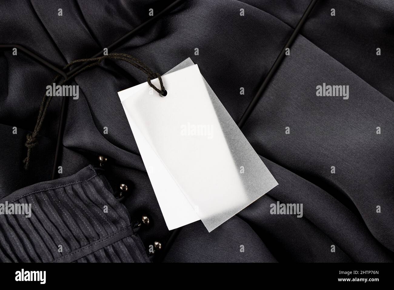 Imitare un'etichetta vuota per il testo di colore bianco su una blusa di seta grigia con bottoni Foto Stock