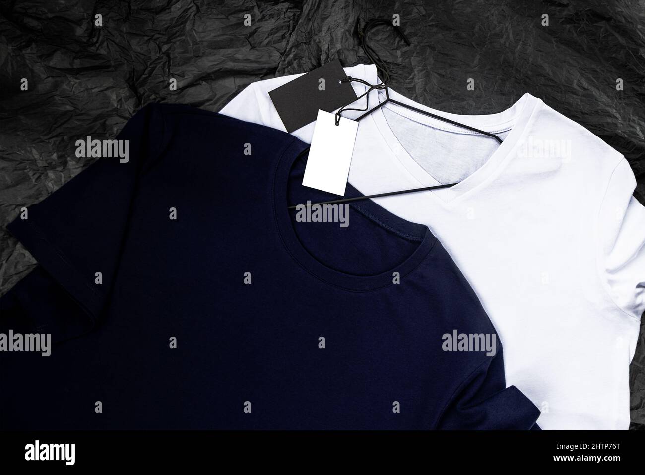 Mockup di una t-shirt in cotone blu e bianco, su sfondo nero. Primo piano con tag Foto Stock