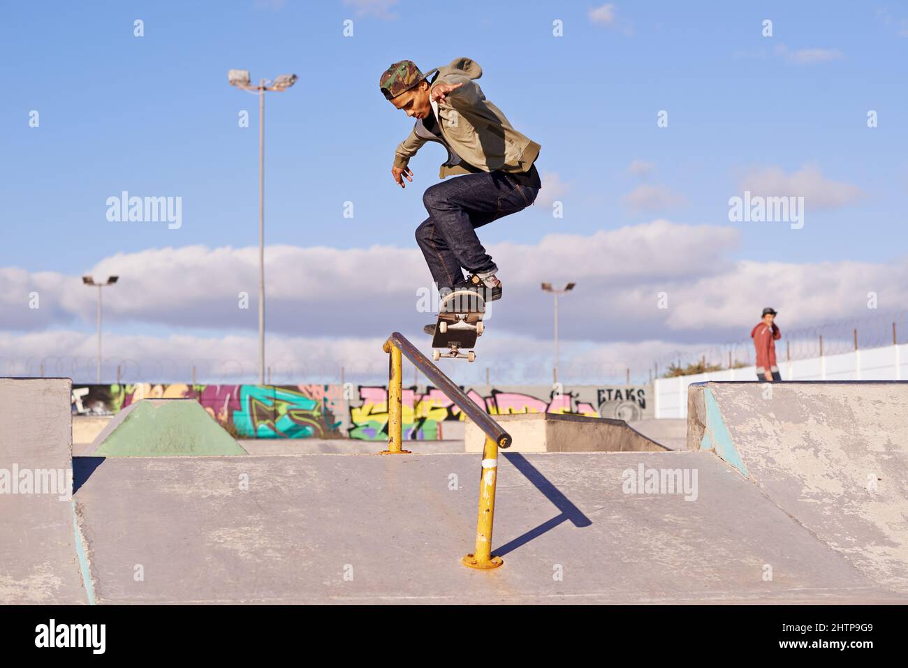 Macinare come un professionista. Colpo di uno skateboarder che esegue un trucco su una ferrovia. Foto Stock
