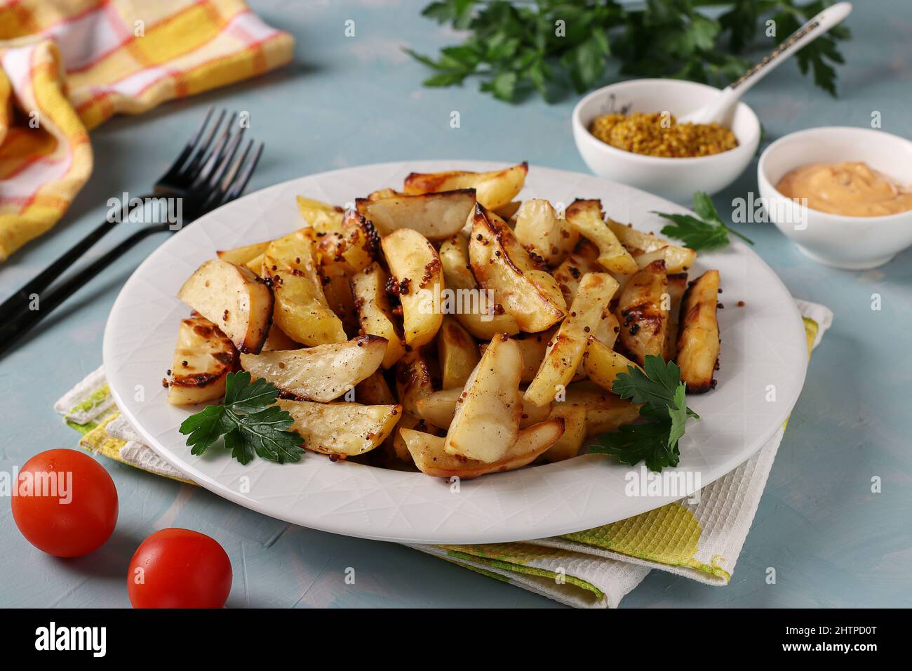 Patate al forno con senape e salsa di paprika in piatto su sfondo blu  chiaro Foto stock - Alamy