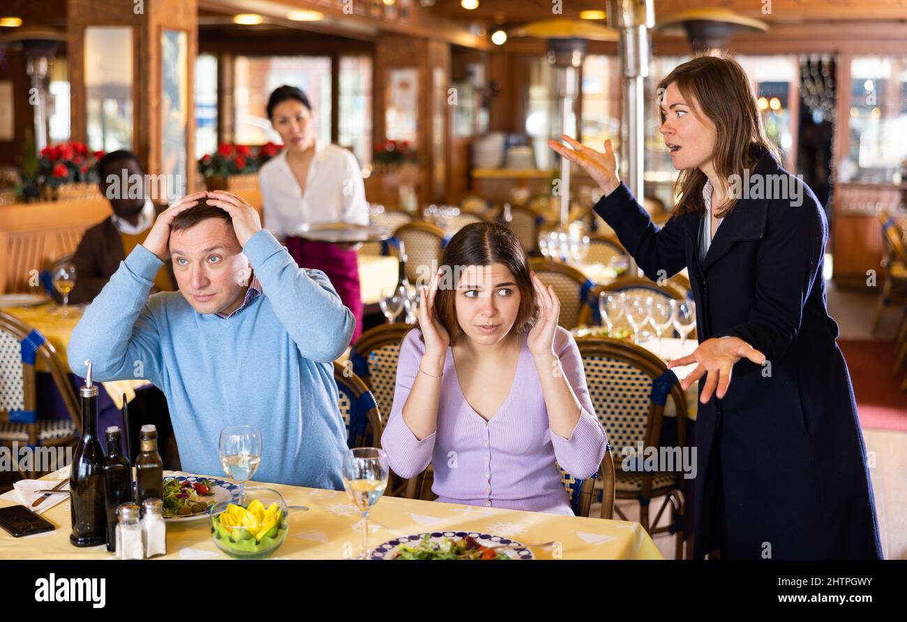 Donna che litigava con il marito e la padrona nel ristorante Foto Stock