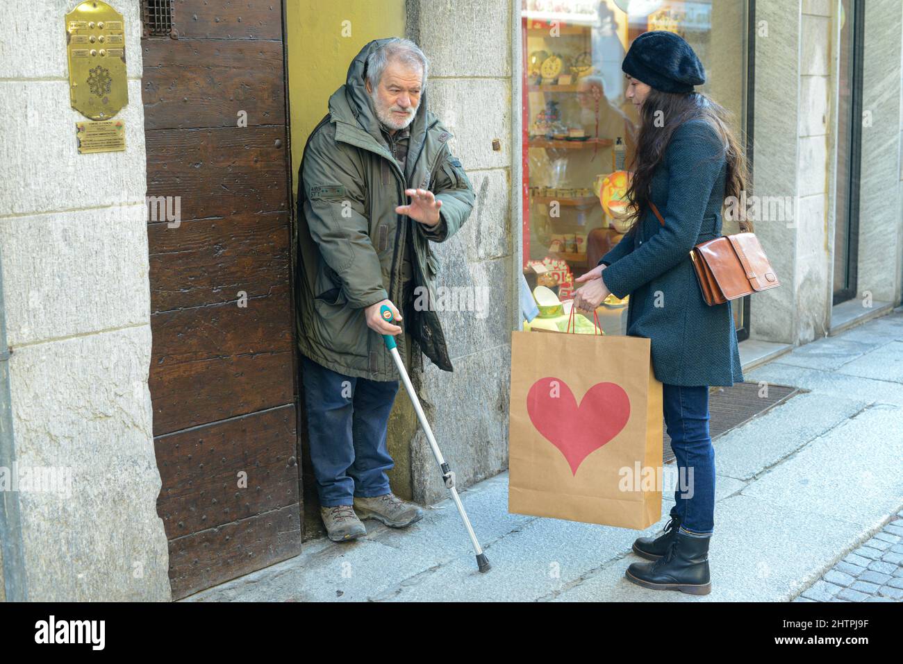 Donna ispanica volontariato, portando generi alimentari a disposizione del vecchio uomo Foto Stock