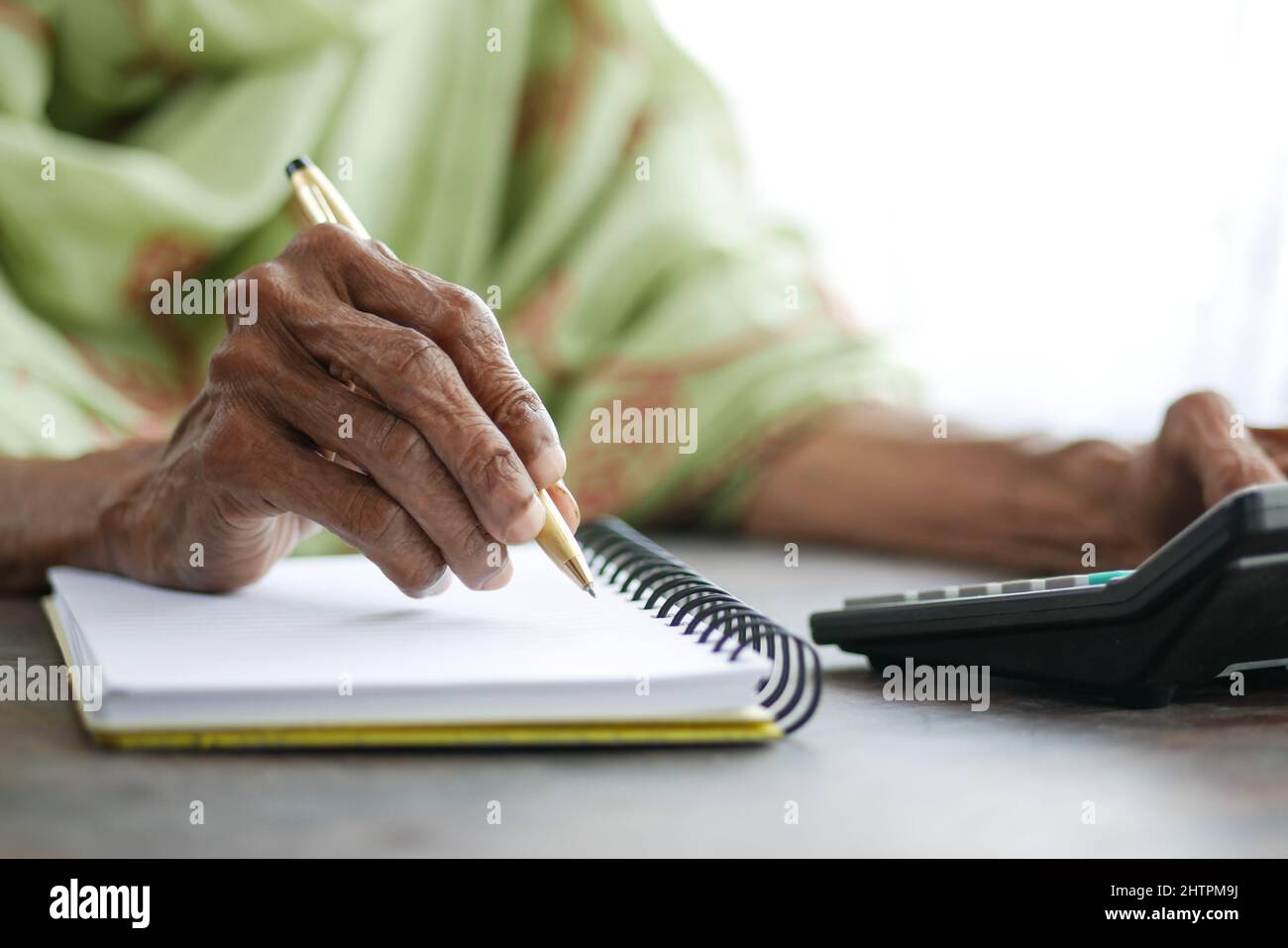 Primo piano di donne senior mano scrivere su blocco note. Foto Stock