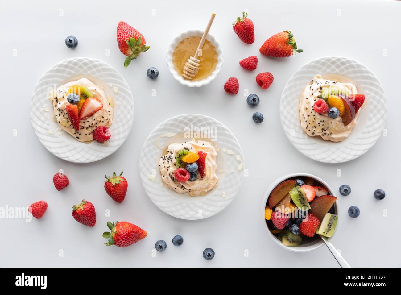 Vista dall'alto verso il basso di meringhe fatte in casa con frutta fresca e miele. Foto Stock