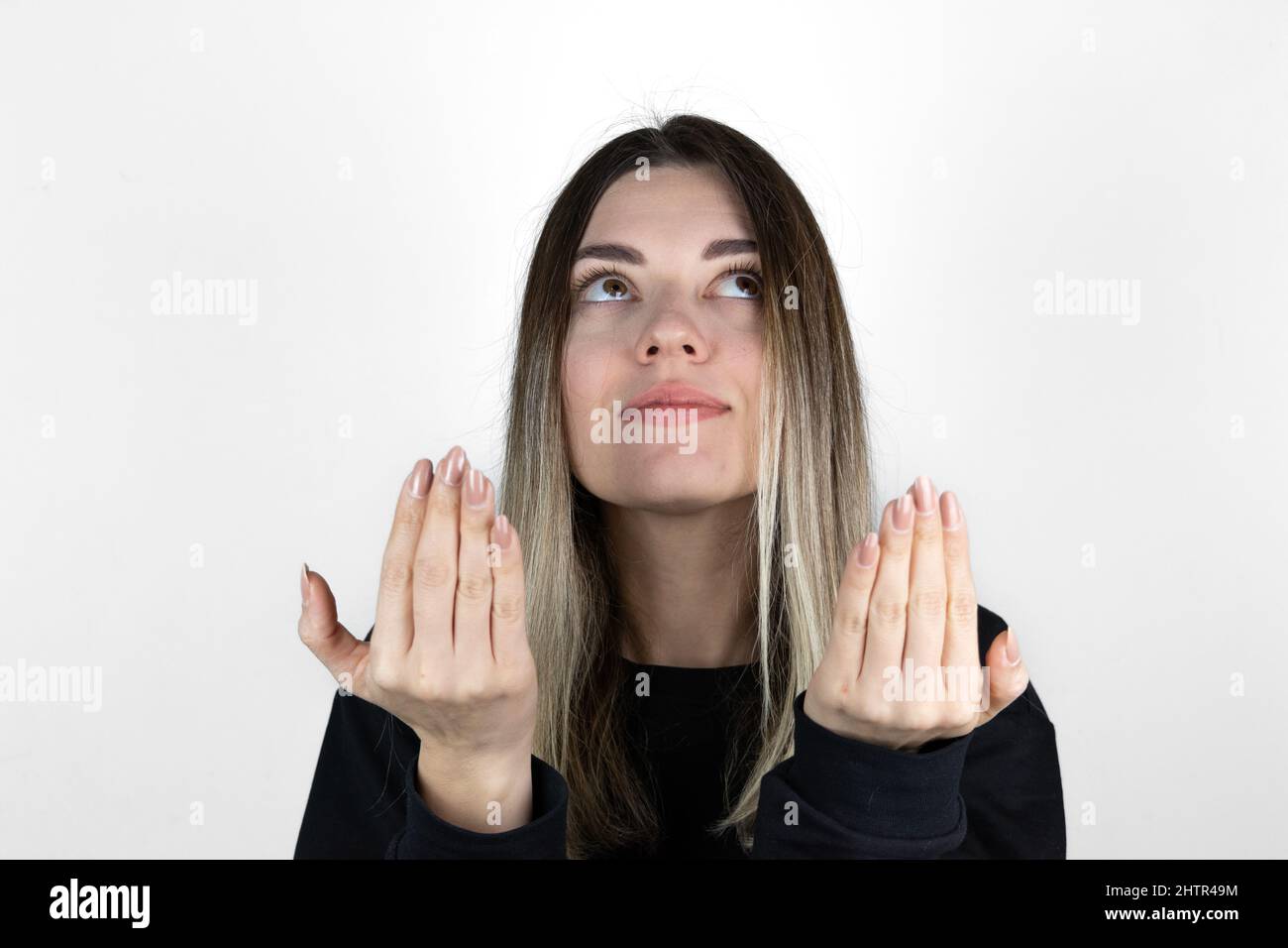 La ragazza musulmana sta alzando le mani e pregando su sfondo bianco. Copia e incolla. Spazio di testo. Foto Stock