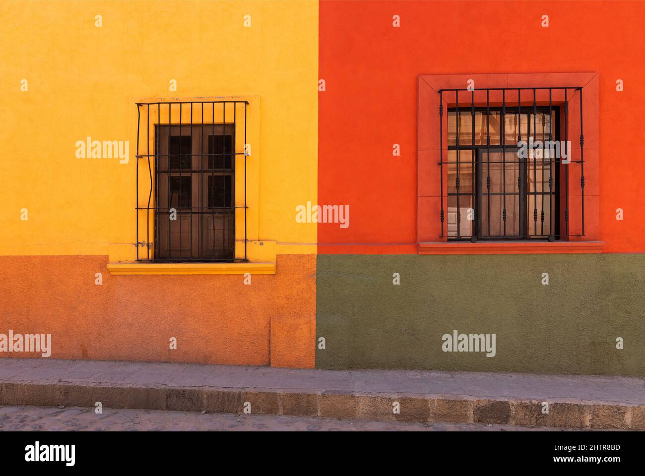 Messico, Stato di Guanajuato, San Miguel de Allende, colorati edifici dell'epoca coloniale spagnola che costeggiano una strada Foto Stock