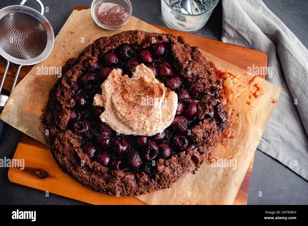 Torta al cioccolato Bourbon Cherry con panna montata: Rustica galette di ciliegia al cioccolato fondente della foresta nera con panna montata cosparse di co Foto Stock