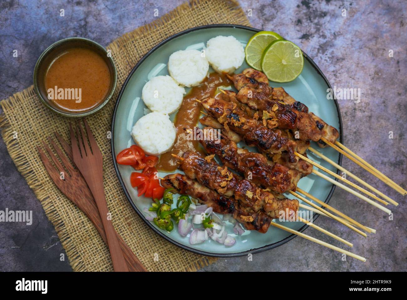 Cibo indonesiano famoso : Sate ayam (satay di pollo), servito con salsa di arachidi e torta di riso o lontong Foto Stock