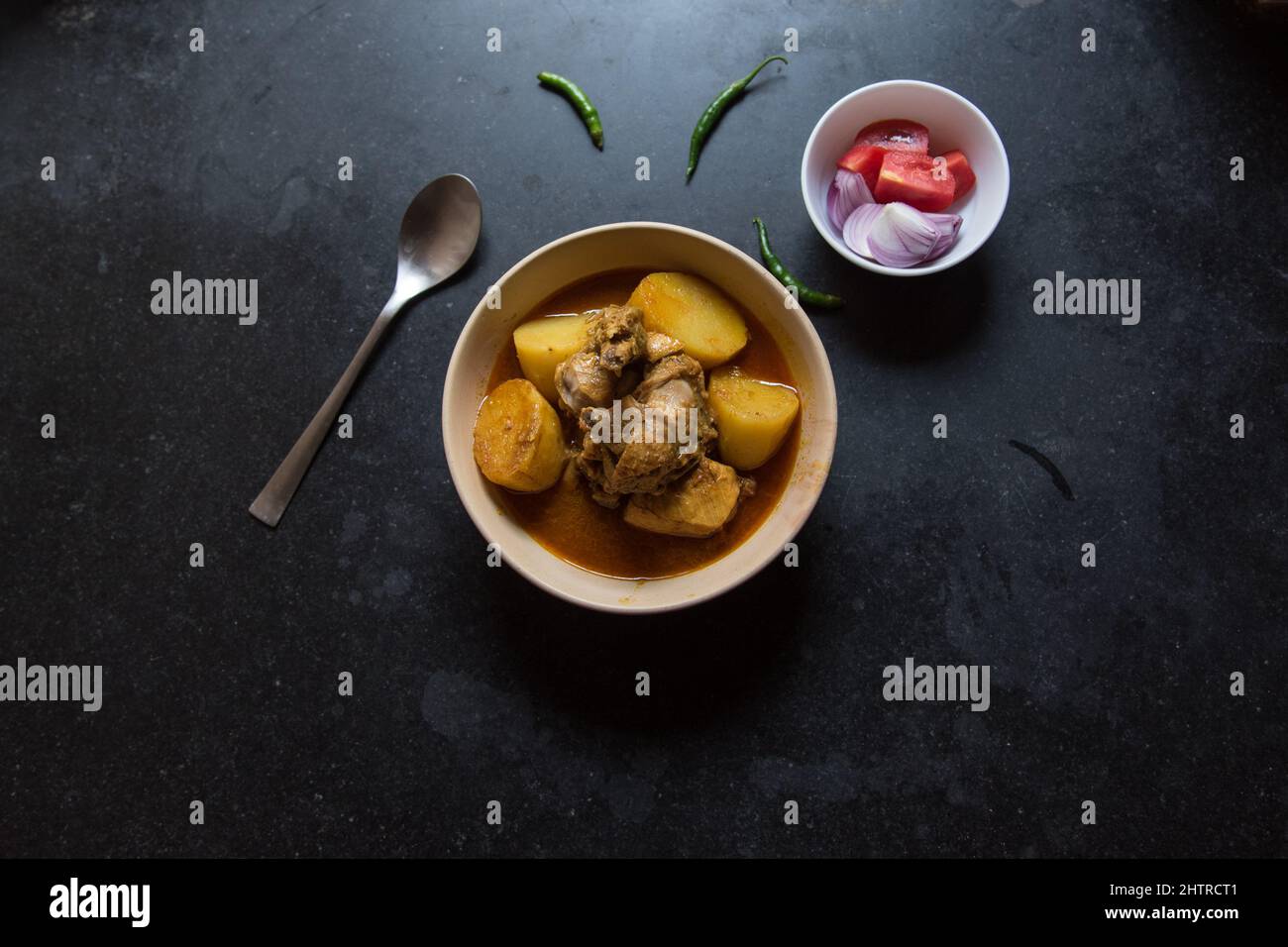 Curry di pollo in stile indiano servito in una ciotola su sfondo scuro. Foto Stock