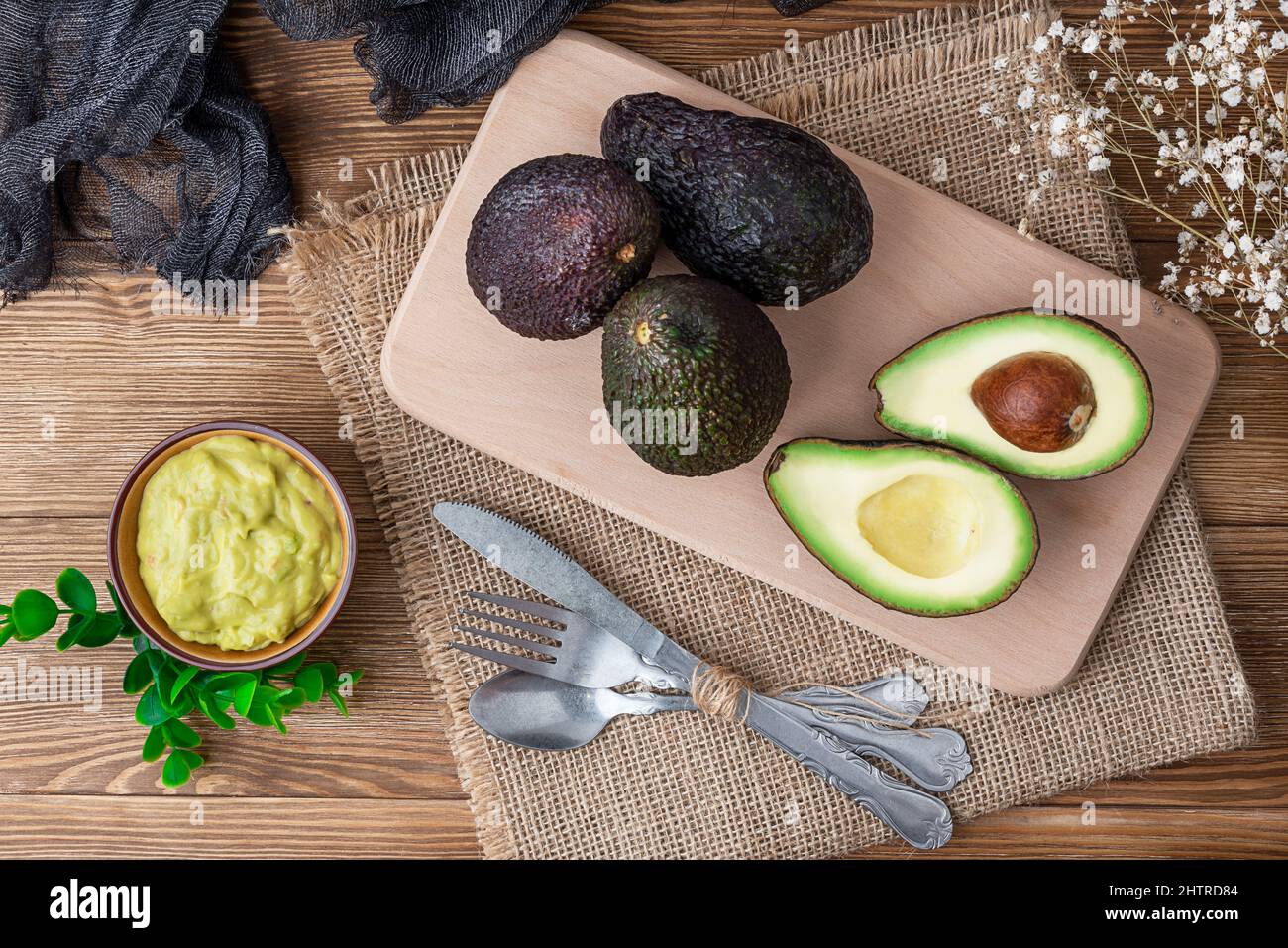 Set di avocado con salsa guacamole su un tavolo di legno con argenteria Foto Stock