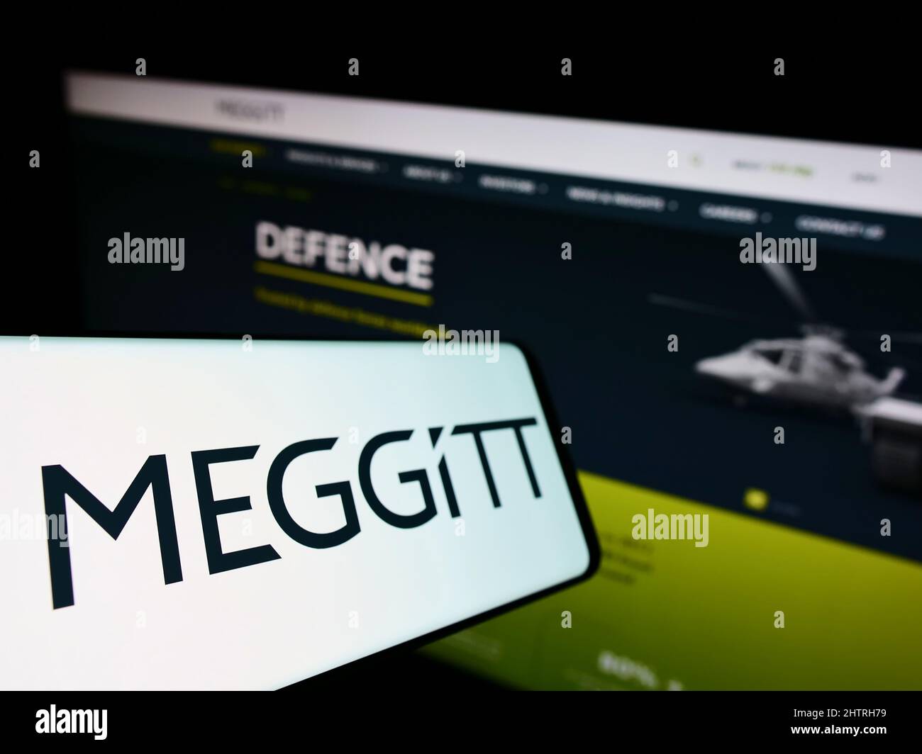 Smartphone con logo della società aerospaziale britannica Meggitt plc sullo schermo di fronte al sito Web aziendale. Mettere a fuoco sulla sinistra del display del telefono. Foto Stock