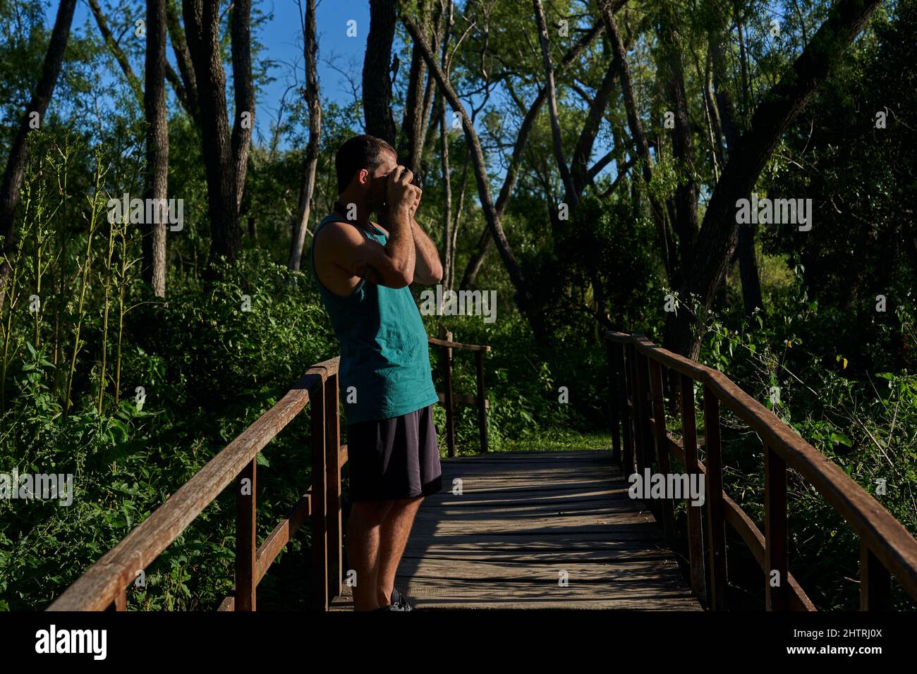 giovane che fotografa in natura con una macchina fotografica d'epoca Foto Stock